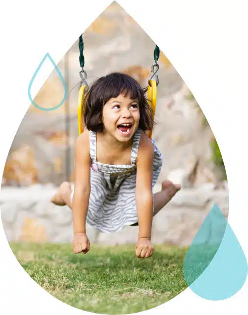 A young patient with hypertension symptoms smiles and plays on a swing.