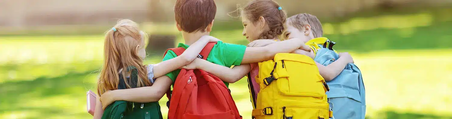 A group of child hypertension patients wearing backpacks gather in a group together