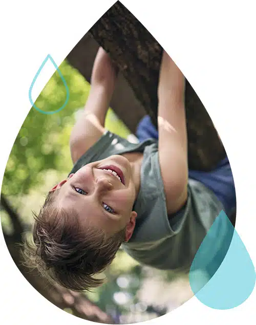 A young patient with hypertension smiles and hangs upside down from a tree.